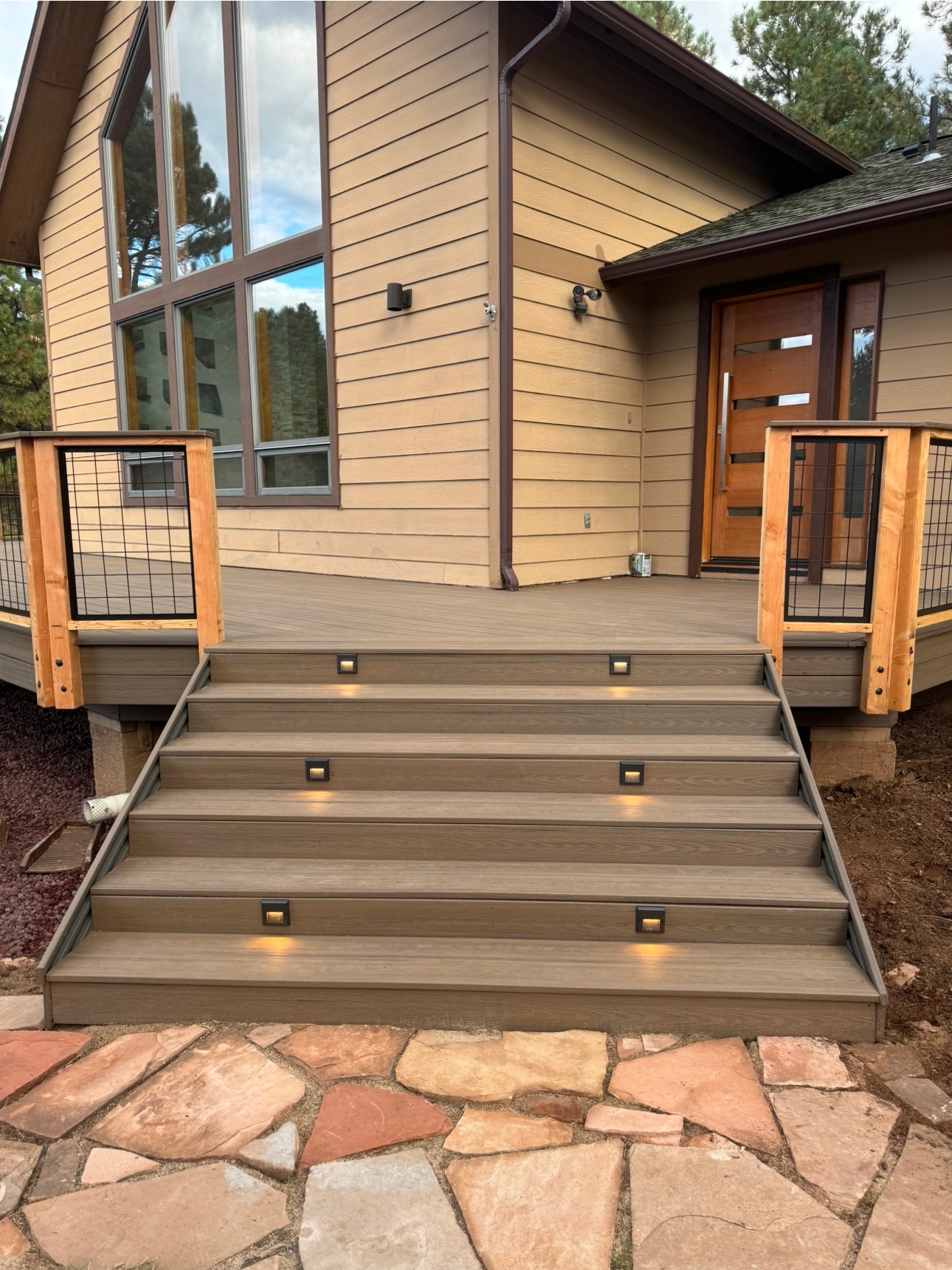 Beautiful composite deck stairs with built-in lighting and wire mesh railings